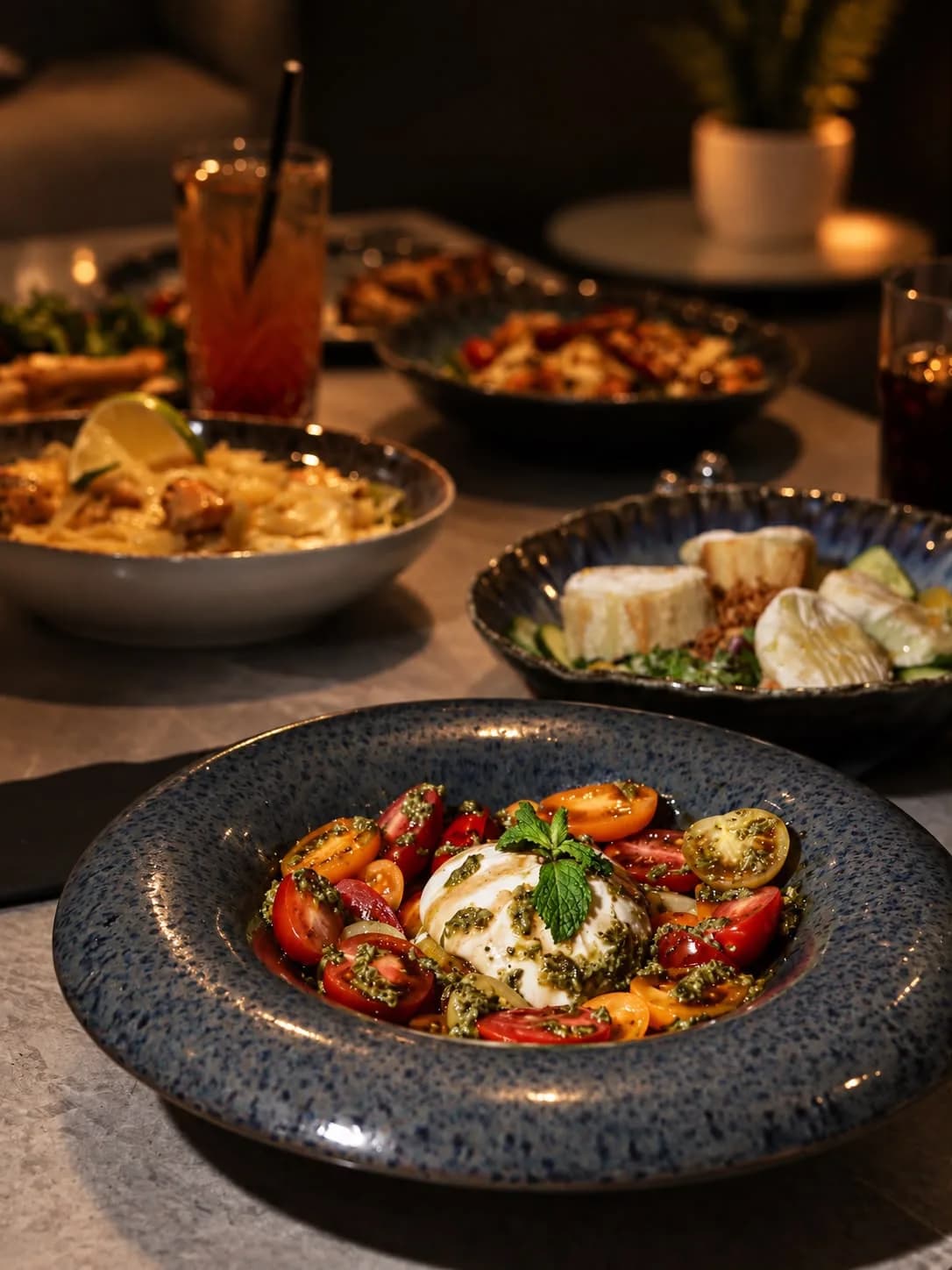 Table dressée à La Parisienne à Toulouse : burrata, pâtes au saumon et brochettes, ambiance feutrée aux reflets dorés